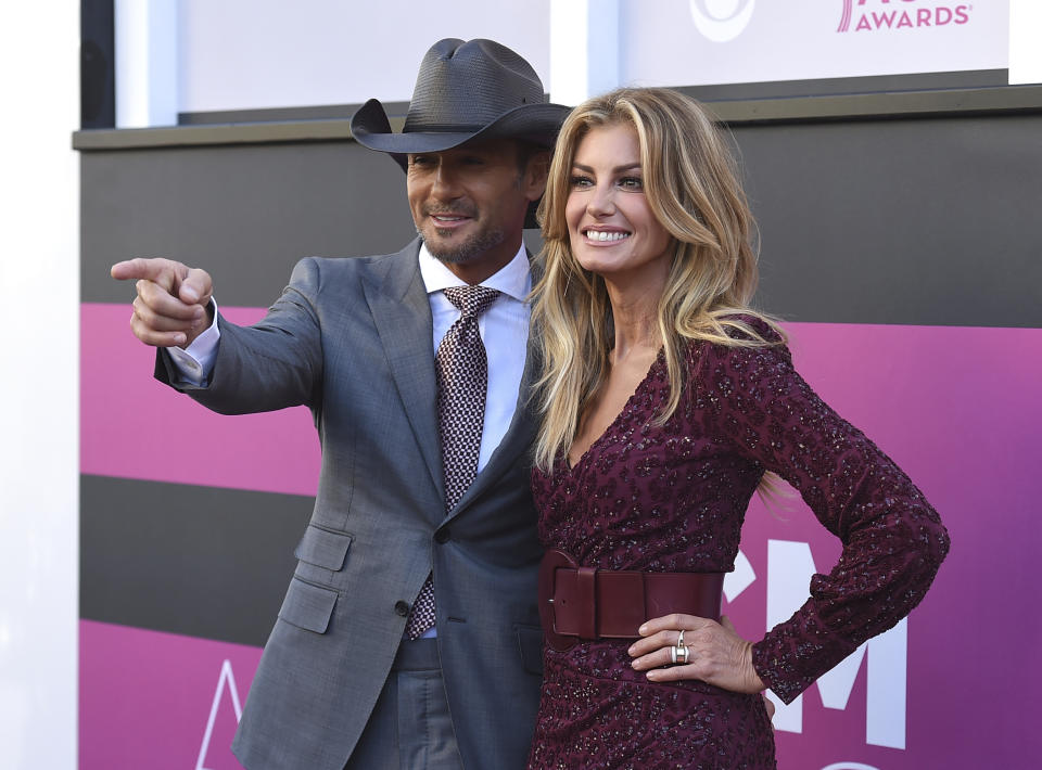 FILE - In this Sunday, April 2, 2017, file photo, Tim McGraw, left, and Faith Hill arrive at the 52nd annual Academy of Country Music Awards at the T-Mobile Arena in Las Vegas. The government's small business lending program has benefited millions of companies, with the goal of minimizing the number of layoffs Americans have suffered in the face of the coronavirus pandemic. Yet the recipients include many you probably wouldn't have expected. A Nashville, Tenn., company called “Road Dog Touring, Inc.” was approved for a small business loan of $2 million to $5 million. The company owns the official website for country singer Tim McGraw, timmccgraw.com, and a joint official site with his wife, Faith Hill, timandfaith.com. (Photo by Jordan Strauss/Invision/AP, File)