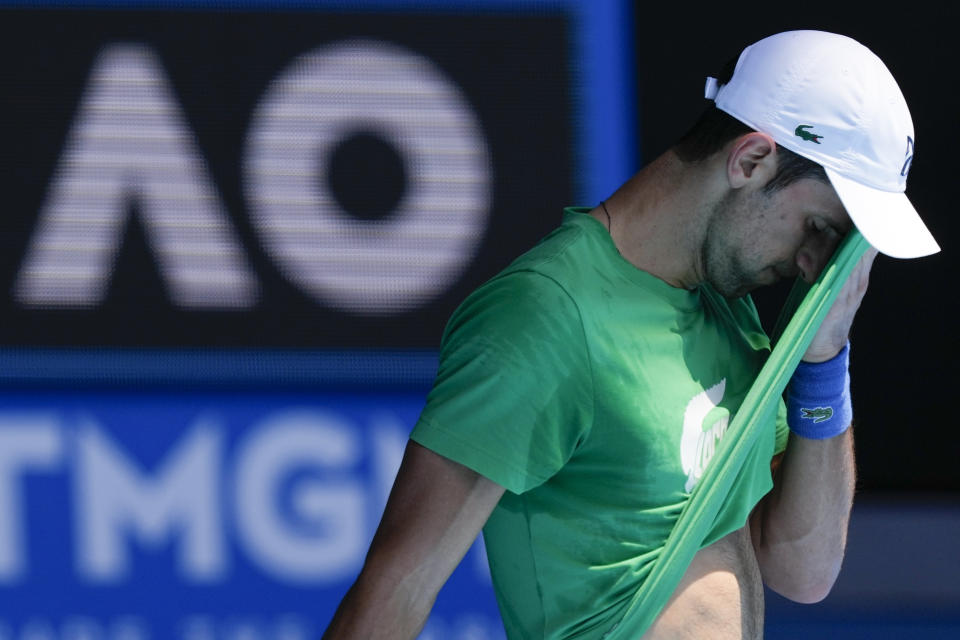 FILE - Defending men's champion Serbia's Novak Djokovic practices on Margaret Court Arena ahead of the Australian Open tennis championship in Melbourne, Australia, Thursday, Jan. 13, 2022. Djokovic will be back in action at the Australian Open when the 2023 Grand Slam season begins next week. He was not able to play in the tournament he's won nine times a year ago because he was not vaccinated against COVID-19 and was deported from the country. (AP Photo/Mark Baker, File)