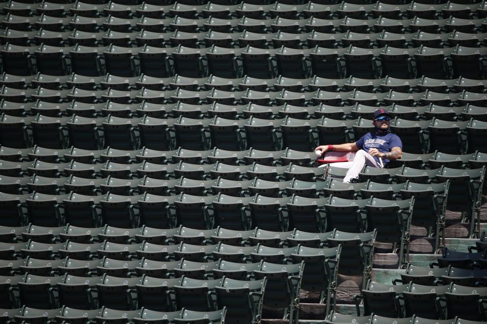 Boston Red Sox's Michael Chavis sits next to the red seat in the bleachers that signifies the longest home run ever hit at Fenway Park, by Ted Williams in 1946, during baseball practice Sunday, July 5, 2020, in Boston. (AP Photo/Michael Dwyer)