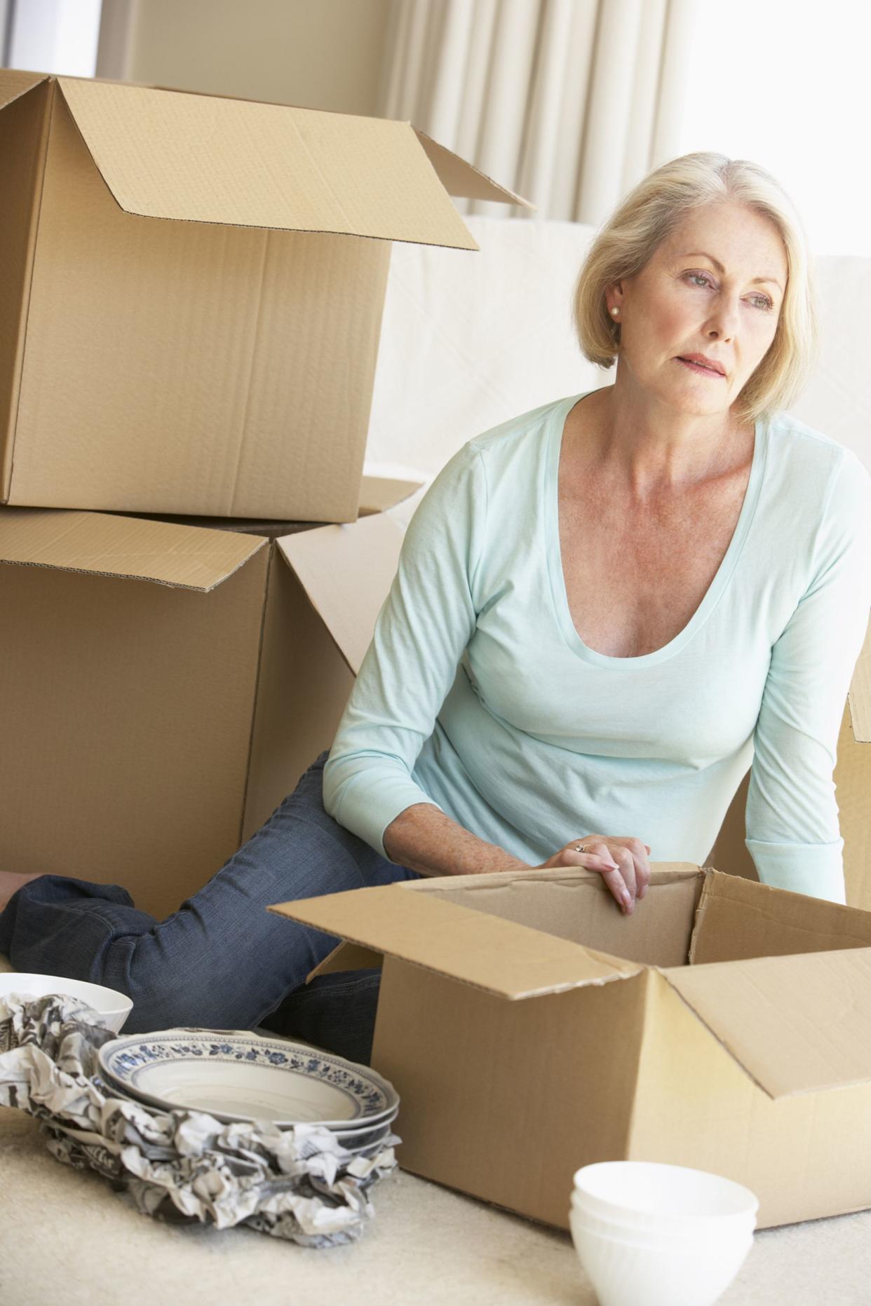 senior woman moving home and packing boxes