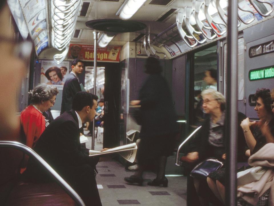 People sit in a partially-filled subway car