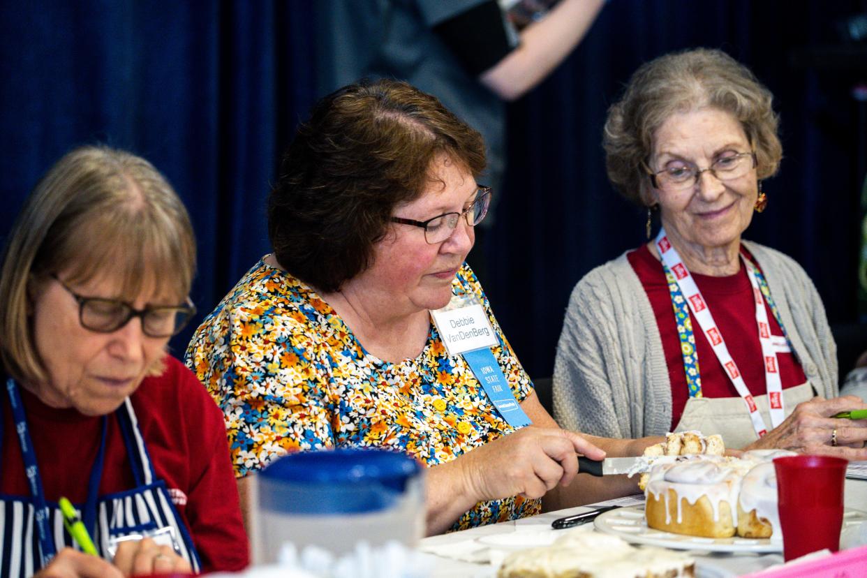 Judge Debbie VanDenBerg assesses a cinnamon roll during the Great Cinnamon Roll Contest inside Elwell Family Food Center during day 10 of the Iowa State Fair.