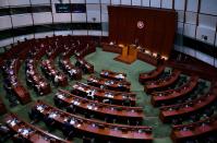 Pro-China lawmakers attend the first and second reading of "Improving Electoral System (Consolidated Amendments) Bill 2021" at the Legislative Council in Hong Kong, Wednesday, April 14, 2021. Hong Kong’s electoral reform bill was introduced in the city’s legislature on Wednesday, setting in motion changes that will give Beijing greater control over the process while reducing the number of directly elected representatives. (AP Photo/Vincent Yu)