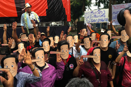 Pro-democracy activists wearing masks mock Thailand's Prime Minister Prayuth Chan-ocha as Pinocchio during a protest against junta at a university in Bangkok, Thailand, February 24, 2018. REUTERS/Panarat Thepgumpanat
