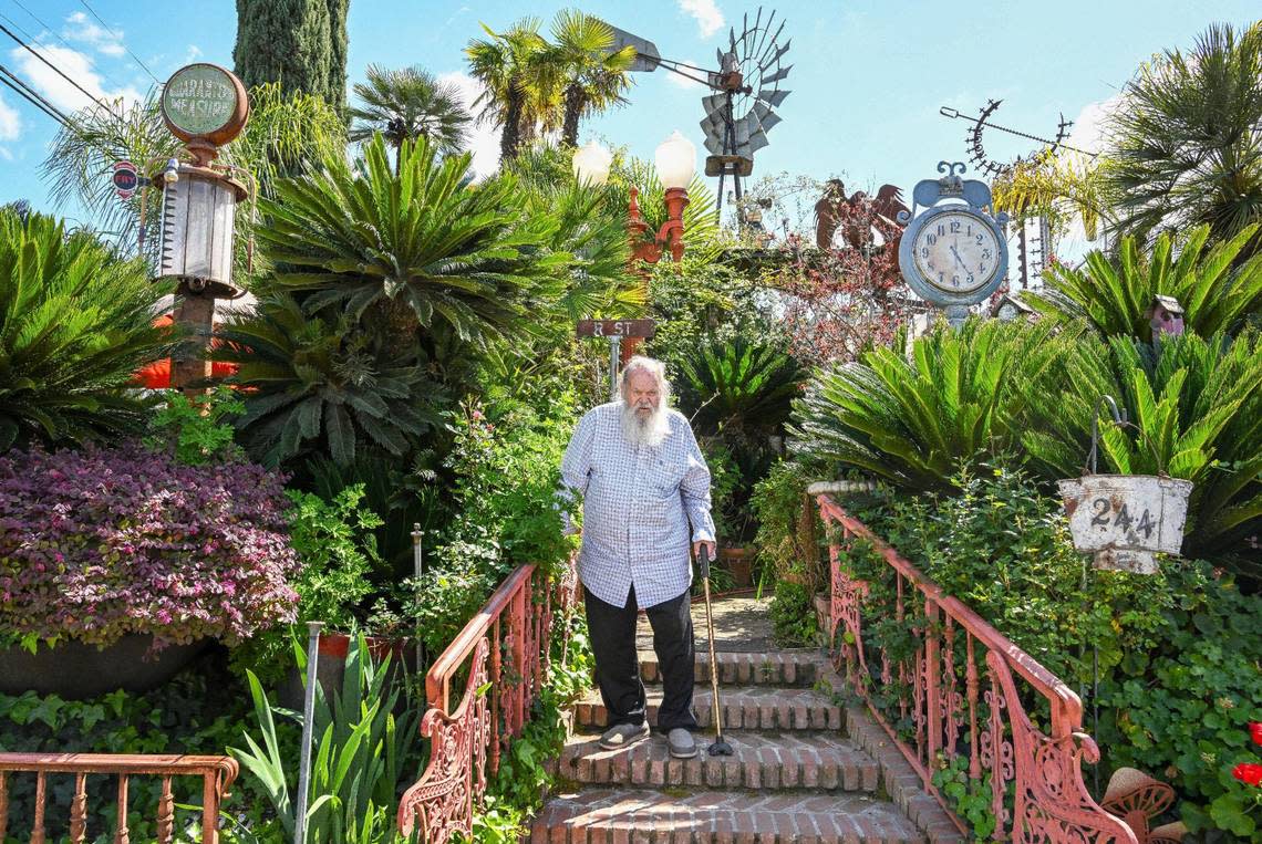 Jim Williams, surrounded by sago palms, old gas pumps, signs, clocks and an old windmill among other collected items and creations, stands on the brick steps leading to the entry of his home in the Fresno High area which he calls “Palazzo Del Sogni,” or Palace of Dreams. CRAIG KOHLRUSS/ckohlruss@fresnobee.com