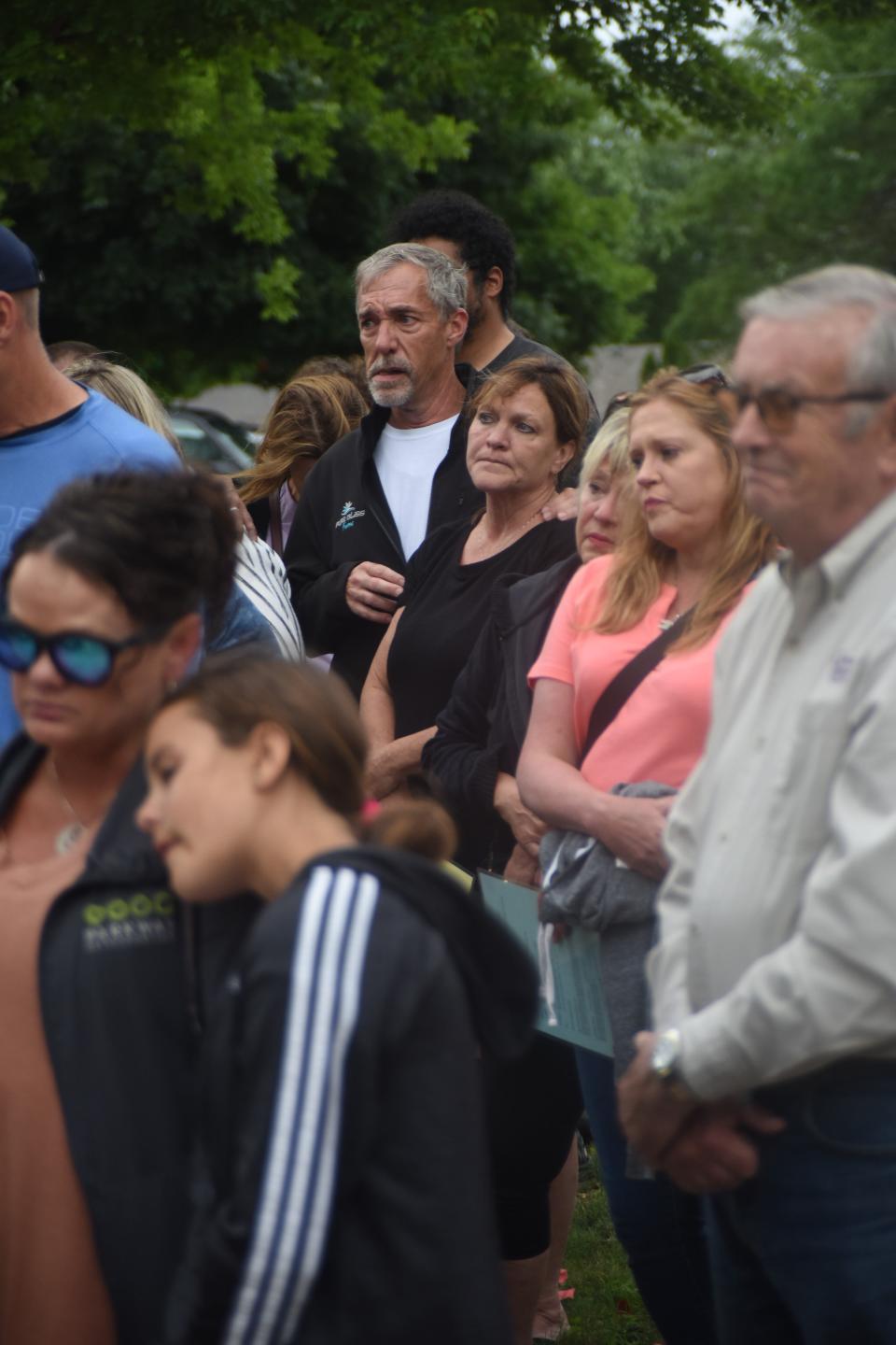 Attendees of the community prayer vigil on Monday, June 17th, 2024 hold a moment of silence for the triple homicide victims who were shot and killed near the corner of West 58th Street and South Drexel Drive, where the vigil took place.
