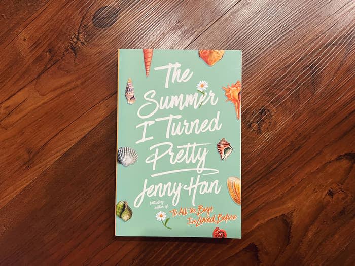 A book titled "The Summer I Turned Pretty" by Jenny Han, author of "To All the Boys I’ve Loved Before," laying on a wooden surface