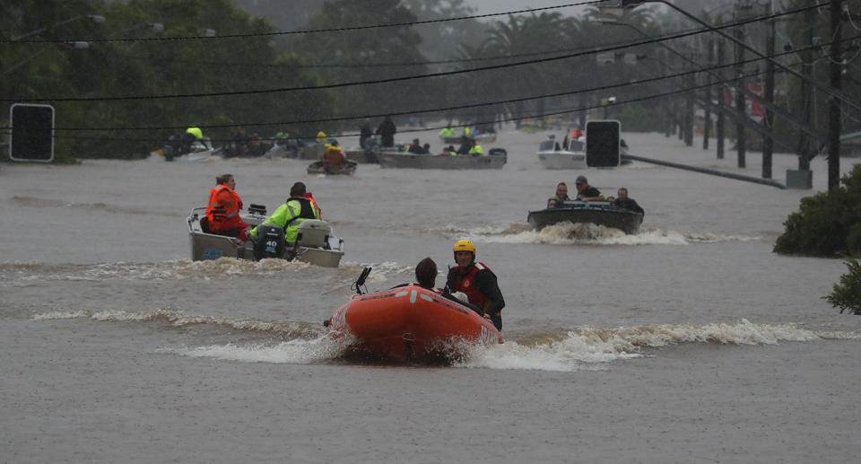 Rescue boats drive across floodwaters in Lismore CBD.