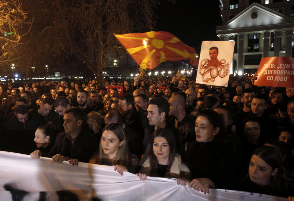 People carry a poster where the leader of the ruling Social Democrats Zoran Zaev is presented as a head of an octopus during a protest march organized by the opposition conservative VMRO-DPMNE party, starting outside the Public Prosecutor's office and ending in front of the complex of national courts, in Skopje, North Macedonia, Tuesday, Feb. 25, 2020. Thousands of conservative opposition party supporters were marching in North Macedonia's capital Skopje late on Tuesday, accusing the outgoing leftist government for strongly influencing prosecution and court decisions. (AP Photo/Boris Grdanoski)