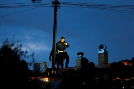 A local police officer patrols on a roof as they arrive to confiscate a villa built illegally by an alleged Mafia family in Rome, Italy, November 20, 2018.  REUTERS/Yara Nardi