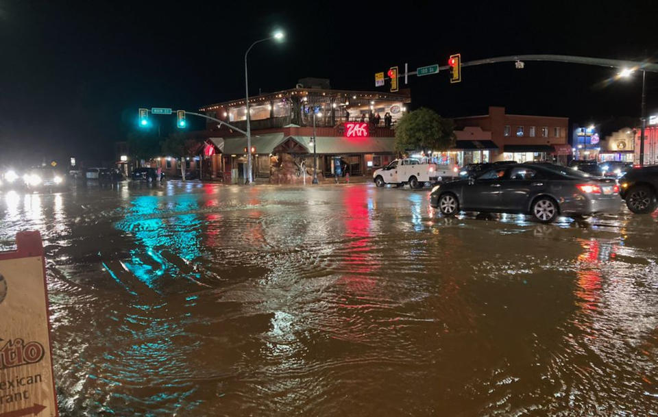 FILE - In this photo courtesy of City of Moab, vehicles navigate high waters at the intersection of South Main Street and 100 South in Moab, Utah, Aug. 20, 2022. Jetal Agnihotri, a 29-year-old from Tucson, Ariz., was still missing Monday, Aug. 22, 2022, after being swept away at Utah's Zion National Park three days earlier as flooding surged through the southwestern United States and imperiled tourists visiting the region's scenic parks. (Rani Derasary/City of Moab via AP, File)