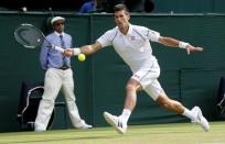 Novak Djokovic of Serbia hits a shot during his match against Bernard Tomic of Australia at the Wimbledon Tennis Championships in London, July 3, 2015. REUTERS/Suzanne Plunkett