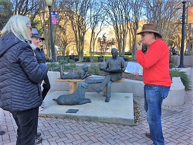 Don Ruane  talks to tour members at the Tallahassee Democrat's Literacy sculpture in Kleman Plaza last year.