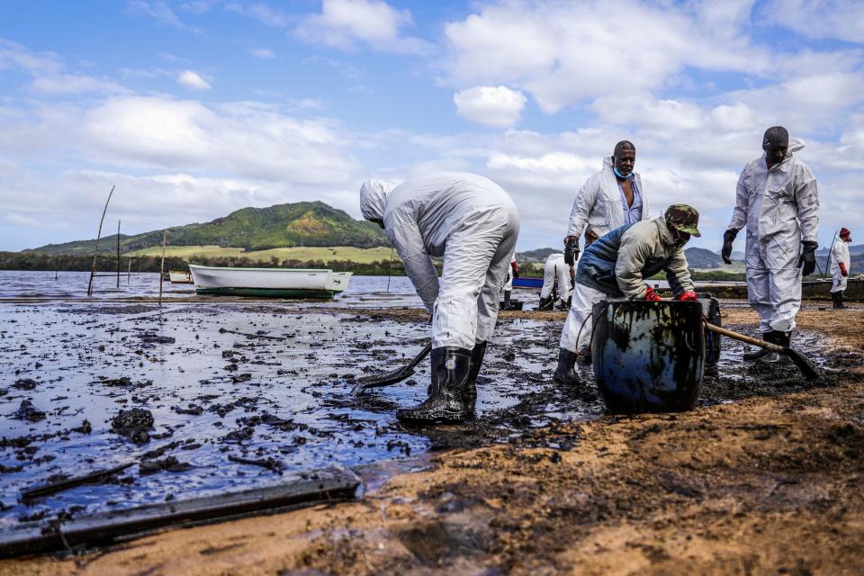 People scoop leaked oil from the vessel MV Wakashio off the coast of Mauritius.