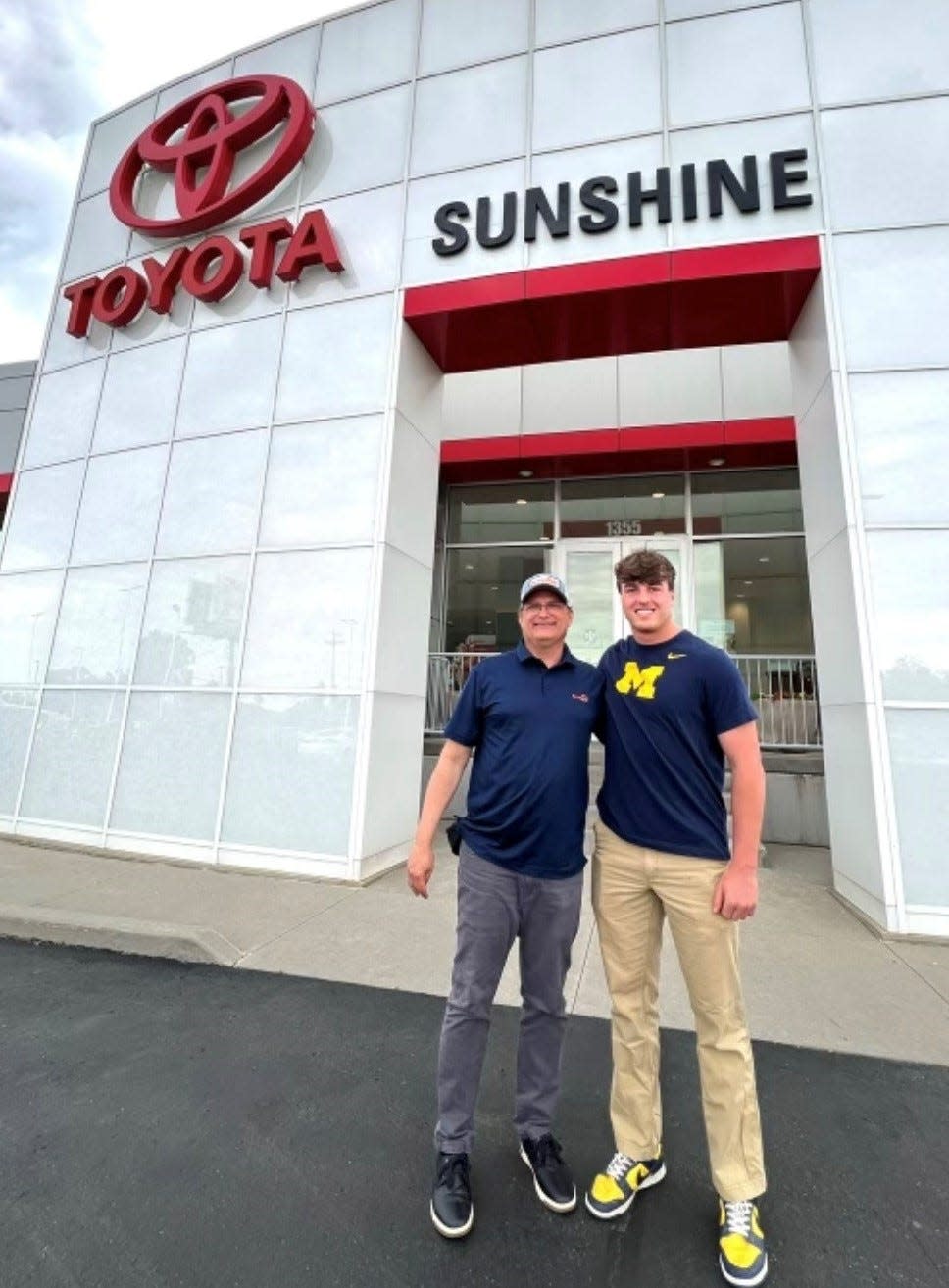 Lakeview High graduate Joel Metzger, right, is a walk-on on the University of Michigan football team and has partnered with Brian Robins, left, and Sunshine Toyota of Battle Creek on a NIL deal.