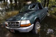 A damaged car is seen in flood waters in St. Amant, Louisiana. REUTERS/Jonathan Bachman