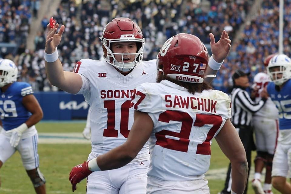Nov 18, 2023; Provo, Utah, USA; Oklahoma Sooners quarterback Jackson Arnold (10) and running back Gavin Sawchuk (27) celebrate a touchdown against the Brigham Young Cougars in the fourth quarter at LaVell Edwards Stadium. Mandatory Credit: Rob Gray-USA TODAY Sports