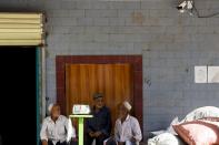 In this Sept. 20, 2018, photo, elderly Uighur men chat outside shophouses in Hotan, in western China's Xinjiang region. While thousands of Uighur Muslims across China’s Xinjiang region are forced into re-education camps, China’s fledgling vision for ethnic unity is taking shape in a village where Han Chinese work and live alongside Uighur minorities. (AP Photo/Andy Wong)