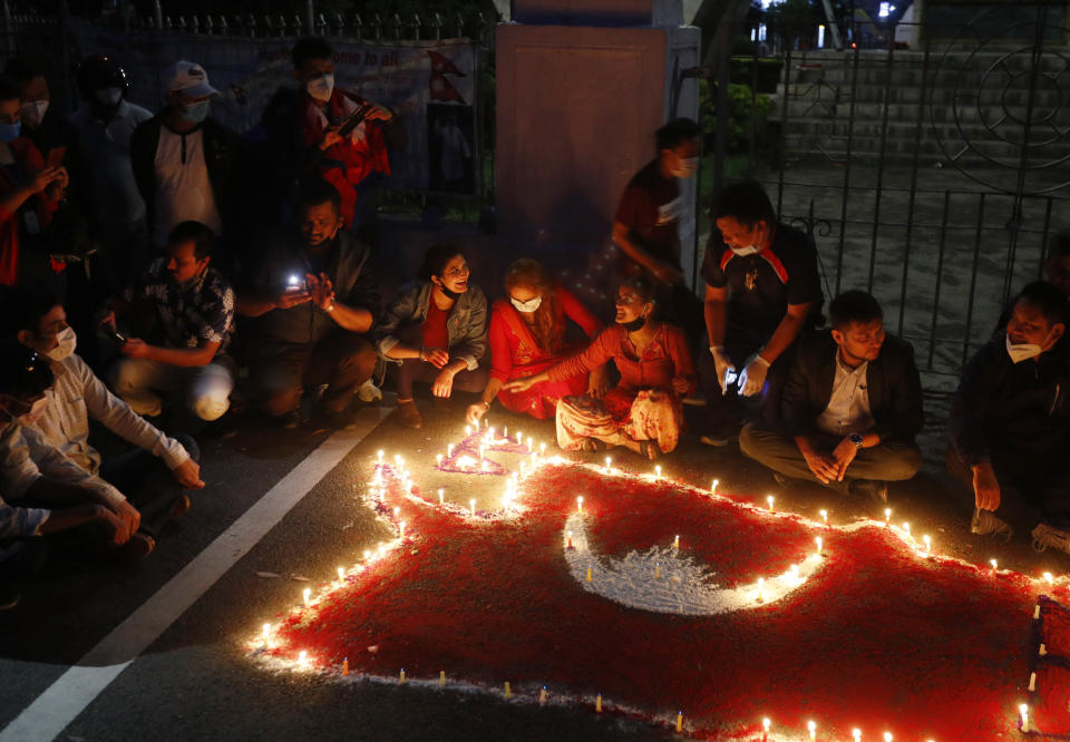 People light candles on an outline of the new map of Nepal drawn on a road as they celebrate the approval of the political map to include territory claimed by both India and Nepal, in Kathmandu, Nepal, Saturday, June 13, 2020. Nepal’s Parliament on Saturday overwhelmingly approved the constitutional amendment to change the nation’s political map. The voting follows the government's issuing of a new map last month that showed the disputed territory within its borders. (AP Photo/Niranjan Shrestha)