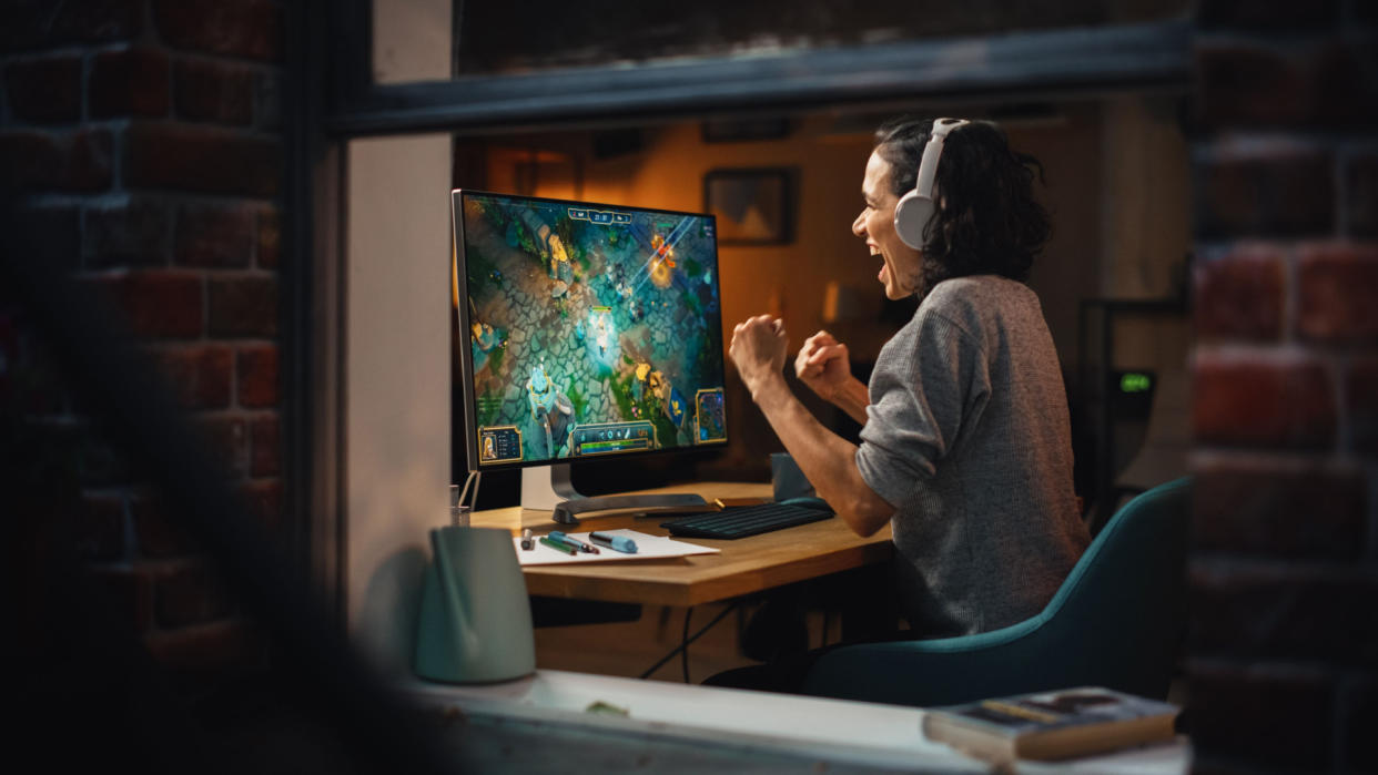  Cheerful Female Gamer Playing Online Video Game on Personal Computer 