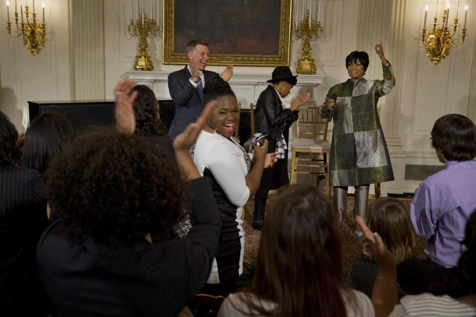 Robert Santelli, executive director of the GRAMMY Museum, left, applauds with singer Janelle Monáe, and Patti LaBelle, after an impromptu song by LaBelle, Thursday, March 6, 2014, in the State Dining Room of the White House in Washington, during a workshop for students as part of the “In Performance at the White House” series, celebrating female artists as the "foremothers” of American music. (AP Photo/Jacquelyn Martin)