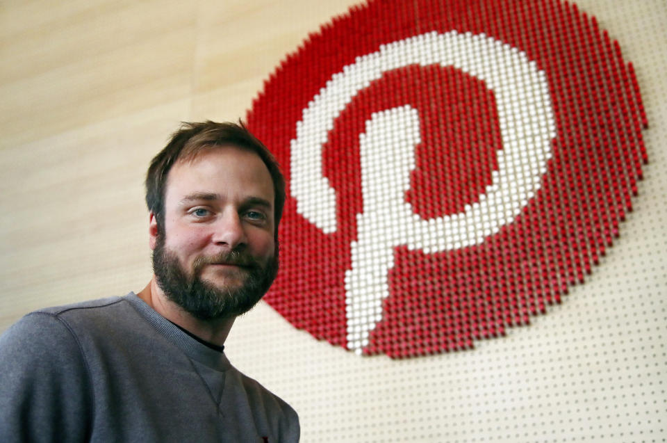 In this Thursday, Oct. 11, 2018, photo Evan Sharp, Pinterest co-founder and chief product officer, poses for a photo stands beside a wall of pegs symbolizing the company logo at Pinterest headquarters in San Francisco. “Social media is about sharing what you are doing with other people,” said Sharp. “Pinterest isn't about sharing. It's mostly about yourself, your dreams, your ideas you want for your future.” (AP Photo/Ben Margot)