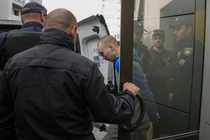 Police escort Russian Sgt. Vadim Shishimarin after a Ukrainian court sentenced him to life in prison in Kyiv, Ukraine, Monday, May 23, 2022. The court sentenced the 21-year-old soldier for killing a Ukrainian civilian, in the first war crimes trial held since Russia's invasion. (AP Photo/Natacha Pisarenko)