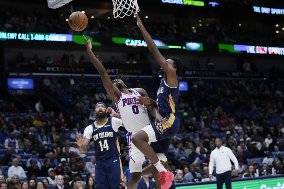 Philadelphia 76ers guard Tyrese Maxey (0) goes to the basket between New Orleans Pelicans forward Herbert Jones and forward Brandon Ingram (14) in the second half of an NBA basketball game in New Orleans, Wednesday, Nov. 29, 2023. The Pelicans won 124-114. (AP Photo/Gerald Herbert)