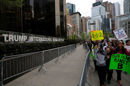 People walk past Trump International Hotel and Tower during the Earth Day 'March For Science NYC' demonstration to coincide with similar marches globally in Manhattan, New York, U.S., April 22, 2017. REUTERS/Andrew Kelly