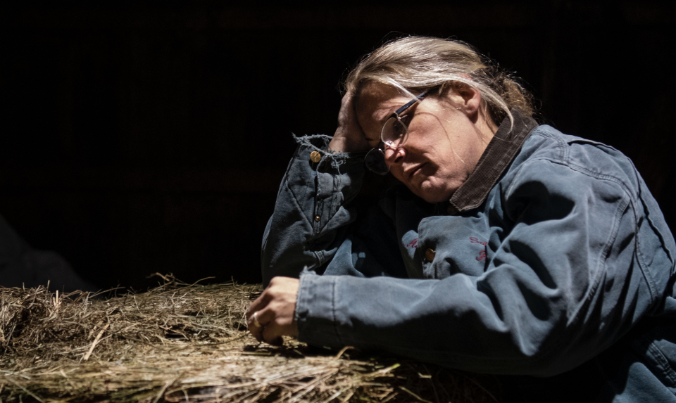 A dairy farmer leans against a round bale of hay after talking about money and being concerned about getting enough food for the family on her monthly grocery run. (Photo: Carolyn Van Houten/The Washington Post via Getty Images)