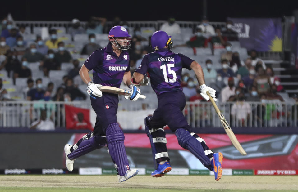 Scotland's batsman George Munsey, left, with captain Kyle Coetzer run between wickets during the Cricket Twenty20 World Cup first round match between Oman and Scotland in Muscat, Oman, Thursday, Oct. 21, 2021. (AP Photo/Kamran Jebreili)