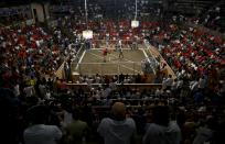 An audience watches a cockfighting match at an arena in Angeles city, north of Manila, Philippines March 11, 2015. Cockfighting has a long history in the Philippines, dating back years prior to the country's Spanish colonisation in 1521. When paying your final respects for a relative or friend, the last thing you might expect to see at the wake is people placing bets on a card game or bingo. Not in the Philippines. Filipinos, like many Asians, love their gambling. But making wagers on games such as "sakla", the local version of Spanish tarot cards, is particularly common at wakes because the family of the deceased gets a share of the winnings to help cover funeral expenses. Authorities have sought to regulate betting but illegal games persist, with men and women, rich and poor, betting on anything from cockfighting to the Basque hard-rubber ball game of jai-alai, basketball to spider races. Many told Reuters photographer Erik De Castro that gambling is only an entertaining diversion in a country where two-fifths of the population live on $2 a day. But he found that some gamble every day. Casino security personnel told of customers begging to be banned from the premises, while a financier who lends gamblers money at high interest described the dozens of vehicles and wads of land titles given as collateral by those hoping lady luck would bring them riches. REUTERS/Erik De Castro PICTURE 6 OF 29 FOR WIDER IMAGE STORY "HIGH STAKES IN MANILA". SEARCH "BINGO ERIK" FOR ALL IMAGES.