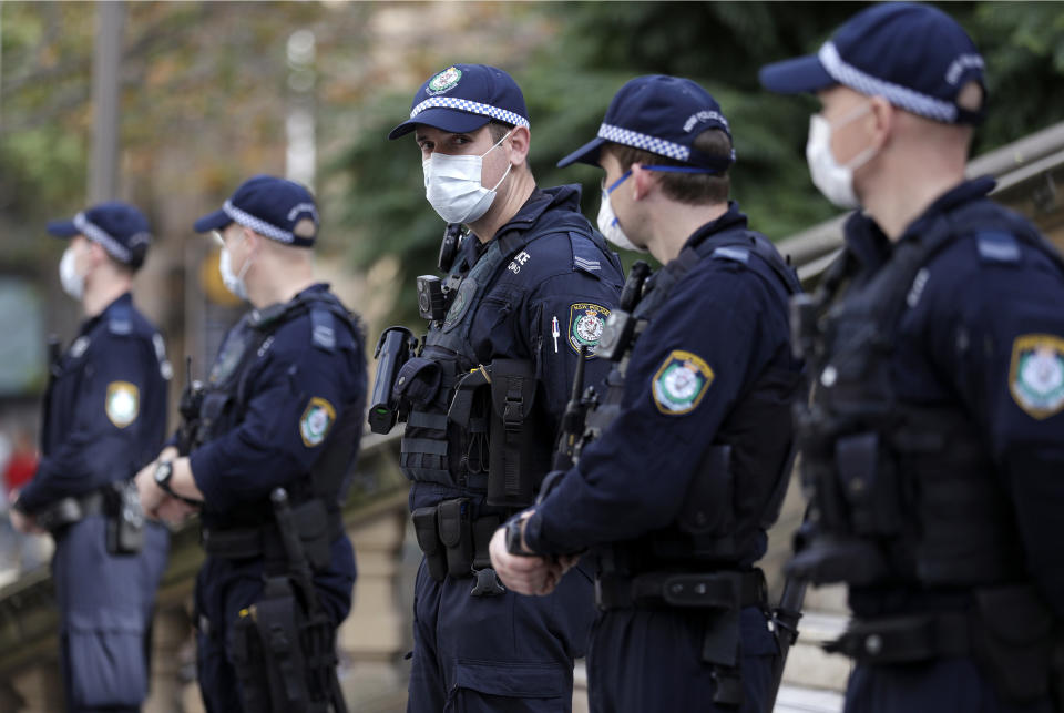 Police stand in front of the Town Hall as protesters gather in Sydney, Saturday, June 13, 2020, during a day of demonstrations across Australia in support of the Black Lives Matter movement and refugee rights. Protesters in Sydney, Adelaide and Perth were urged to stay away by government officials concerned about the risk of spreading the new coronavirus. (AP Photo/Rick Rycroft)