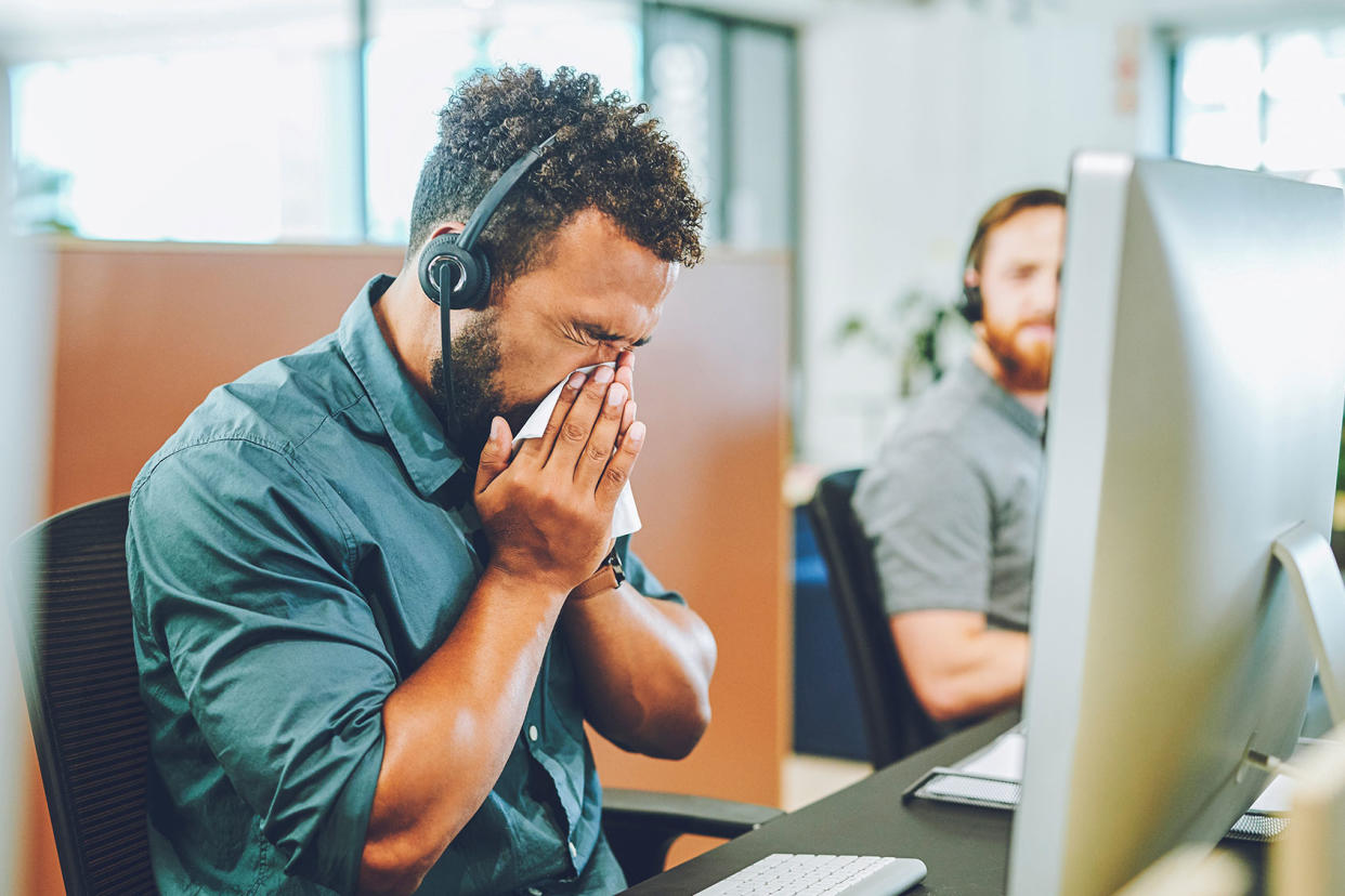 Sick sneezing office worker Getty Images/Charday Penn