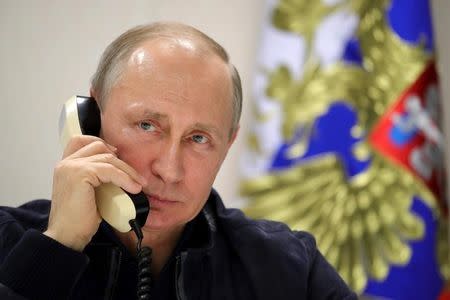 Russian President Vladimir Putin speaks over the phone with Turkish President Tayyip Erdogan while he inspects the work on the Turkish Stream gas pipeline project aboard the Pioneering Spirit pipeline-laying ship in the Black Sea near Anapa, Russia, June 23, 2017. Sputnik/Mikhail Klimentyev/Kremlin via REUTERS