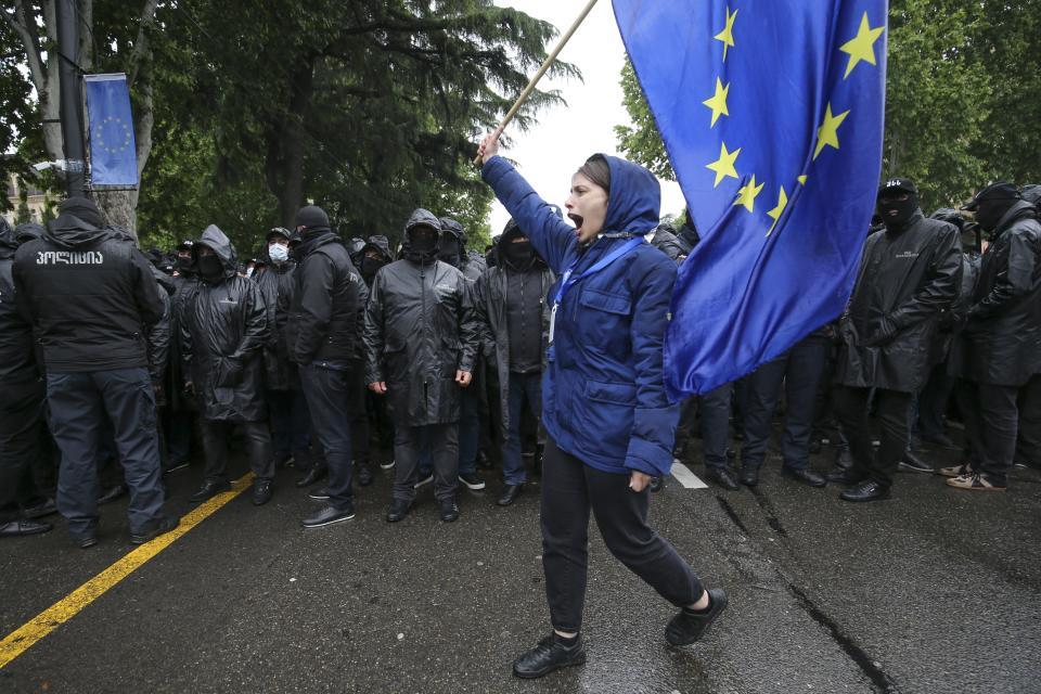 A demonstrator waves an EU flag in front of riot police blocking a street during an opposition protest against "the Russian law", near the Parliament building in the center of Tbilisi, Georgia, Tuesday, May 14, 2024. The Georgian parliament on Tuesday approved in the third and final reading a divisive bill that sparked weeks of mass protests, with critics seeing it as a threat to democratic freedoms and the country's aspirations to join the European Union. (AP Photo/Zurab Tsertsvadze)