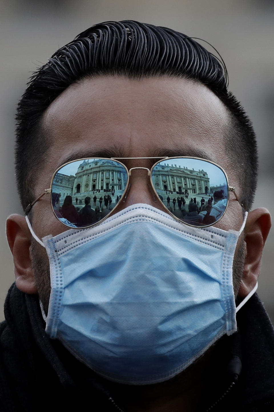 A man wears a face mask in St. Peter's Square at the Vatican during Pope Francis' weekly general audience, Wednesday, Feb. 26, 2020. The viral outbreak that began in China and has infected more than 80,000 people globally, so far caused 323 cases and 11 deaths in Italy. (AP Photo/Alessandra Tarantino)