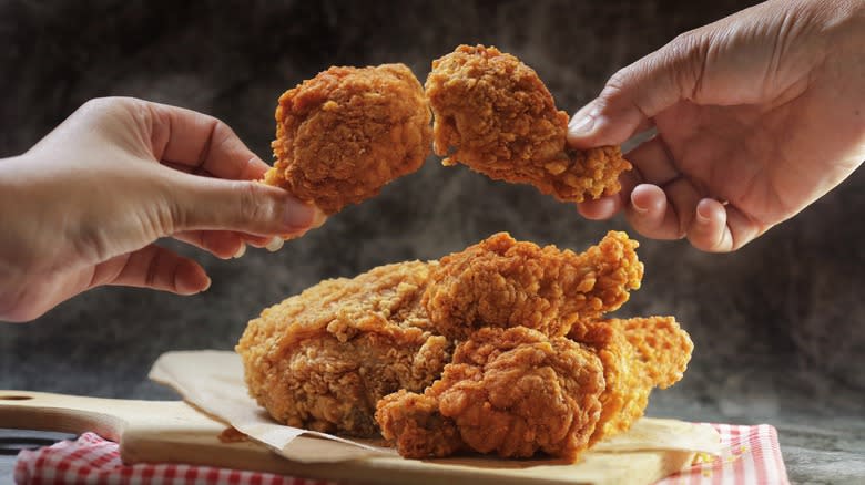 people holding fried chicken wings