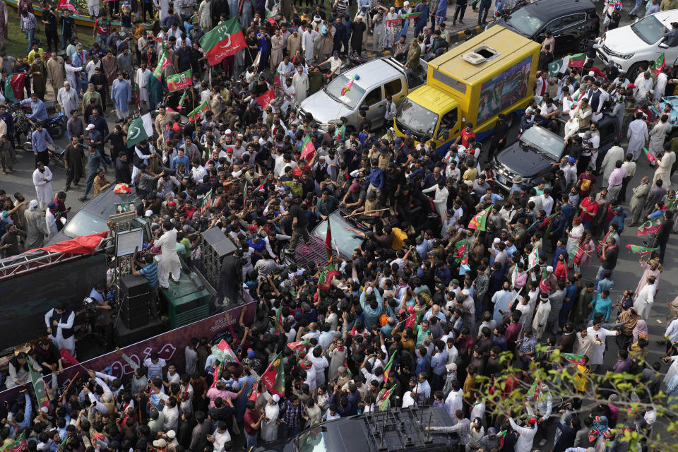 A vehicle, center, carrying former premier Imran Khan is surrounded by his supporters as he leads a rally to mark International Labor Day, in Lahore, Pakistan, Monday, May 1, 2023. (AP Photo/K.M. Chaudary)