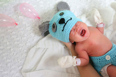 A newborn baby wearing a dog costume to celebrate the New Year of the Dog is pictured at the nursery room of Paolo Chokchai 4 Hospital in Bangkok, Thailand, December 28, 2017. REUTERS/Athit Perawongmetha