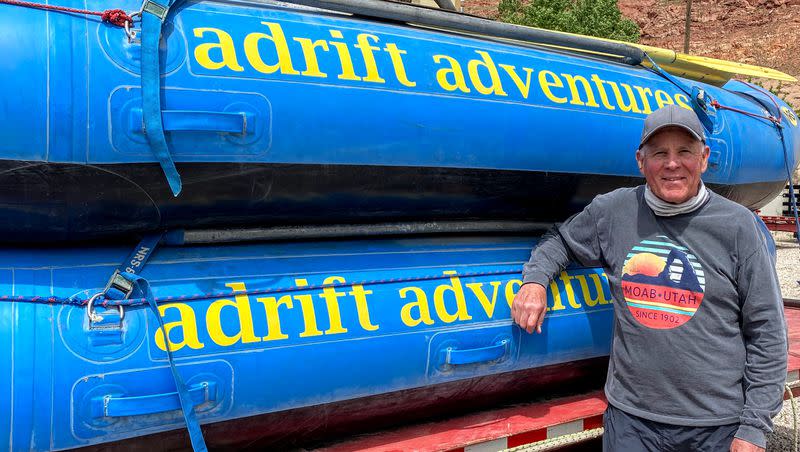 Myke Hughes, owner of Adrift Adventures in Moab, poses with two of his rafts.