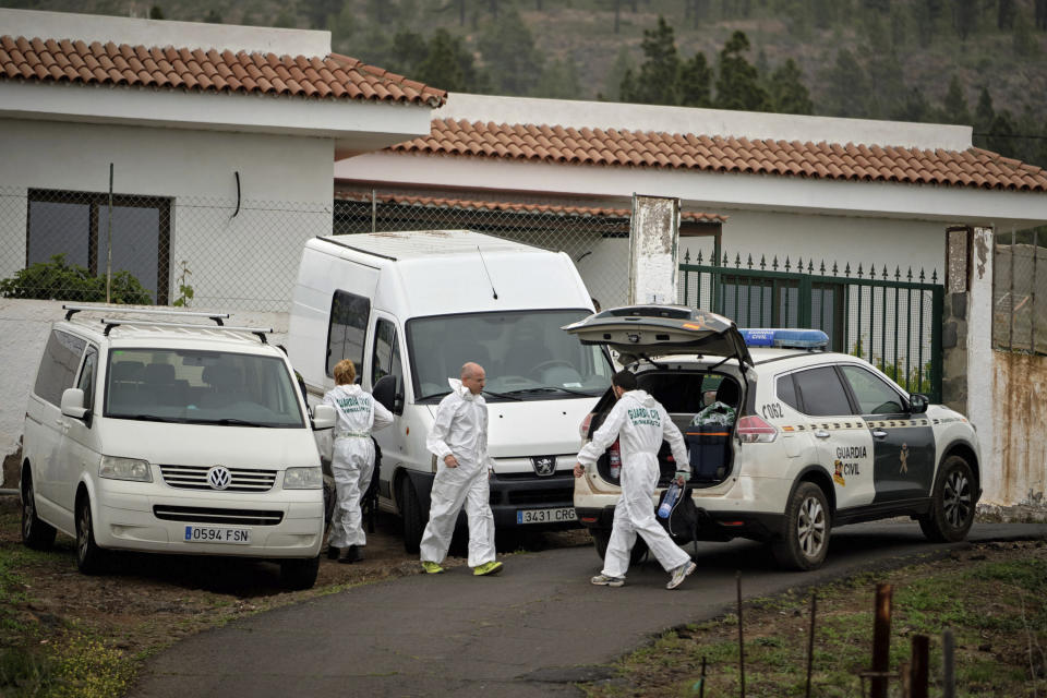 Members of the Spanish Civil Guard work on a road leading to a cave at the base of the Teide volcano, where a mother and son were found in Santa Cruz de Tenerife in the Canary Islands, Spain, Wednesday, April 24, 2019. The bodies of a German woman and her 10-year-old son were found in a cave in the Canary island of Tenerife, on Wednesday said the Civil Guard, adding that the boy's father, who was also German, had been arrested. (AP Photo/Andres Gutierrez)