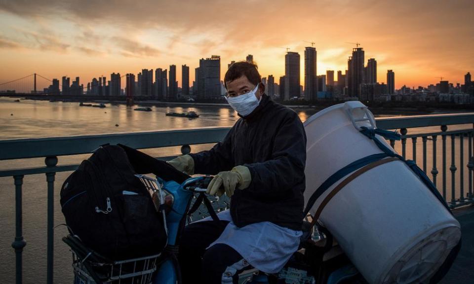 A man wearing a protective face mask riding a scooter in Wuhan in China’s central Hubei province