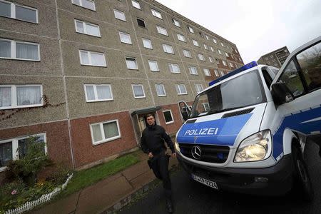 A German police officer walks outside a building, that also serves as an accommodation facility for refugees, in the village of Suhl, Germany, October 25, 2016. REUTERS/Kai Pfaffenbach