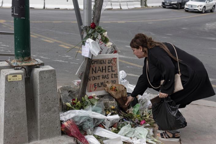 A woman pays her respects at the site where Nahel died, shortly after his funeral, in Nanterre (Getty)