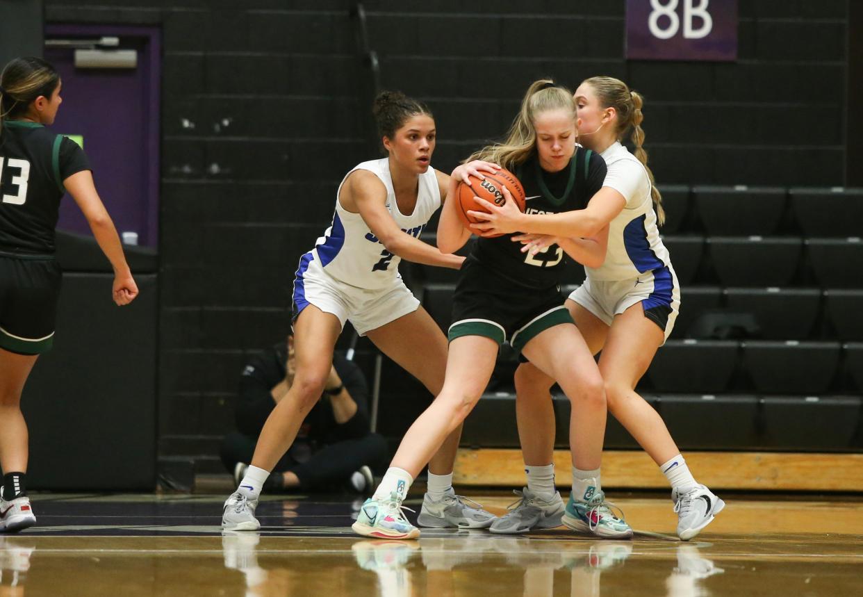 West Salem’s Lizzy Bennett clings to the ball under heavy coverage as the West Salem Titans take on South Medford in the OSAA 6A state basketball quarterfinals at the Chiles Center in Portland Wednesday, March 8, 2023.