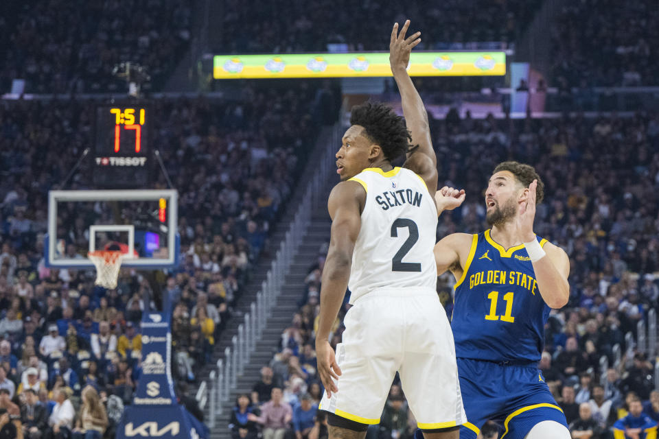 Golden State Warriors guard Klay Thompson (11) reacts to scoring a 3-point basket as Utah Jazz guard Collin Sexton (2) watches during the first half of an NBA basketball game, Sunday, April 7, 2024, in San Francisco. (AP Photo/Nic Coury)