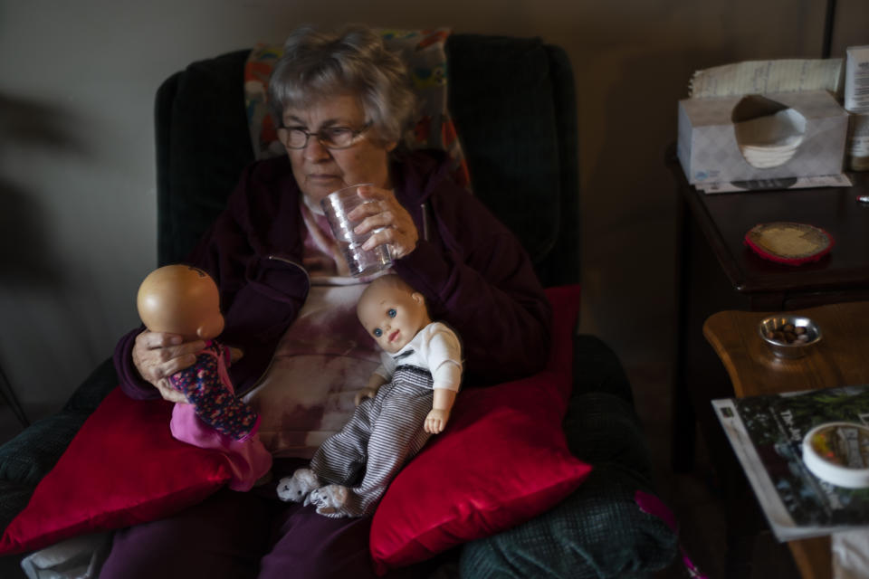 Betty Bednarowski looks at her dolls which she calls her "babies" as she sits in her chair most of the day, Monday, Nov. 29, 2021, in Rotterdam Junction, N.Y. (AP Photo/Wong Maye-E)