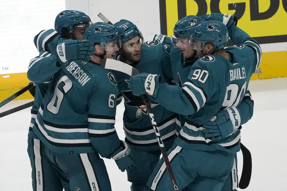 San Jose Sharks center Luke Kunin, middle, is congratulated by teammates after scoring against the Washington Capitals during the third period of an NHL hockey game in San Jose, Calif., Monday, Nov. 27, 2023. (AP Photo/Jeff Chiu)