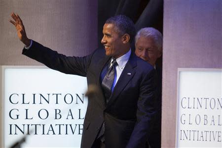 U.S. President Barack Obama (L) and former U.S. President Bill Clinton walk on to the stage during the Clinton Global Initiative 2013 (CGI) in New York September 24, 2013. REUTERS/Carlo Allegri